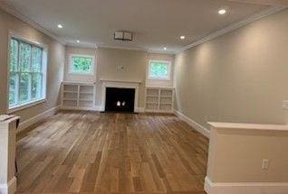220 Mill St, Burlington, MA 01803 - unfurnished living room featuring baseboards, ornamental molding, healthy amount of natural light, a fireplace, and wood finished floors