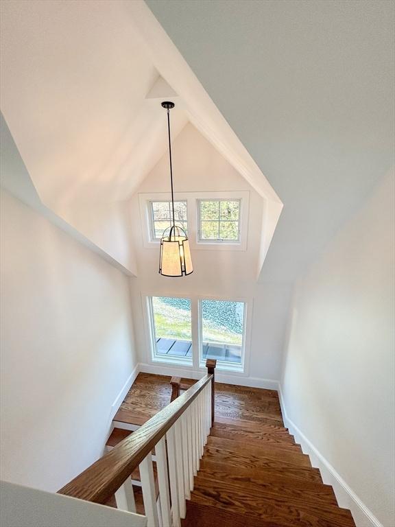 stairway featuring lofted ceiling and hardwood / wood-style flooring