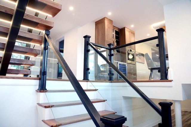 staircase with hardwood / wood-style floors