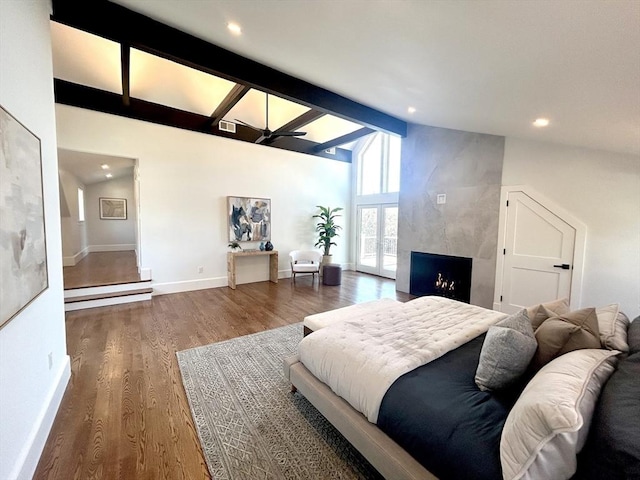 bedroom featuring beam ceiling, ceiling fan, high vaulted ceiling, dark hardwood / wood-style floors, and a fireplace