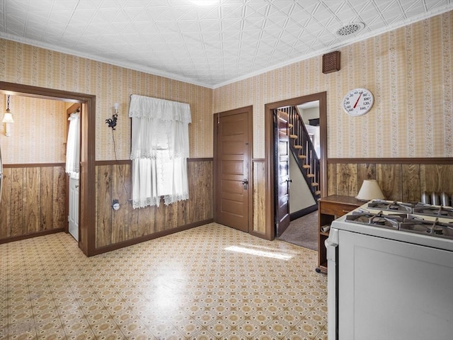 interior space with crown molding and wood walls