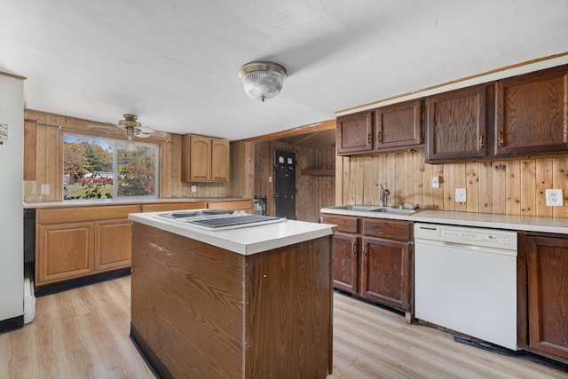 kitchen featuring white appliances, a center island, light hardwood / wood-style floors, ceiling fan, and wooden walls