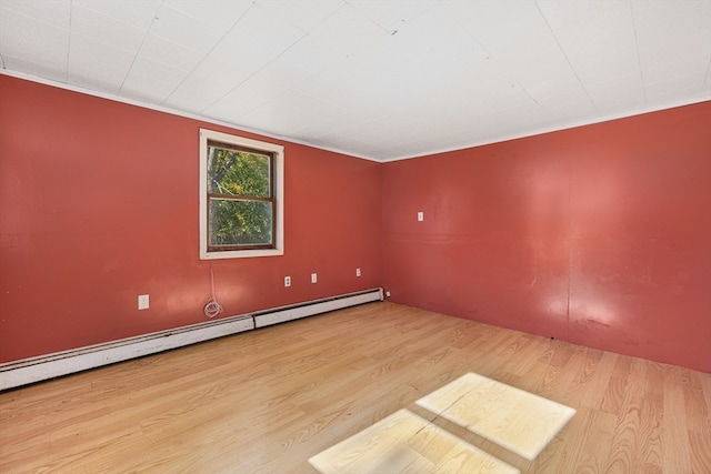 empty room featuring a baseboard radiator, crown molding, and light hardwood / wood-style flooring