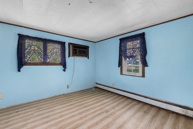 unfurnished room featuring a baseboard radiator, a textured ceiling, light hardwood / wood-style floors, a wall unit AC, and ornamental molding