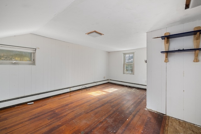 spare room with a baseboard radiator, wooden walls, vaulted ceiling, and dark hardwood / wood-style flooring