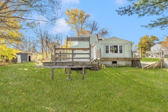 rear view of house with a storage shed, a wooden deck, and a lawn