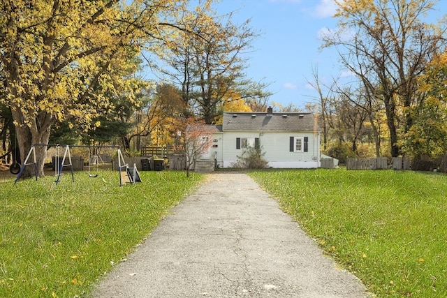 view of front of house with a playground and a front lawn