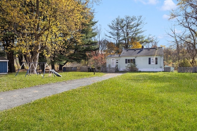 view of front of property featuring a front lawn and a playground