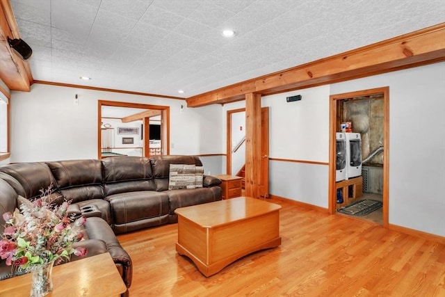 living room with crown molding, washer and clothes dryer, and light wood-type flooring