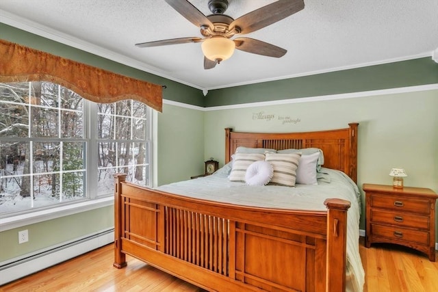 bedroom with crown molding, a baseboard radiator, a textured ceiling, and light wood-type flooring