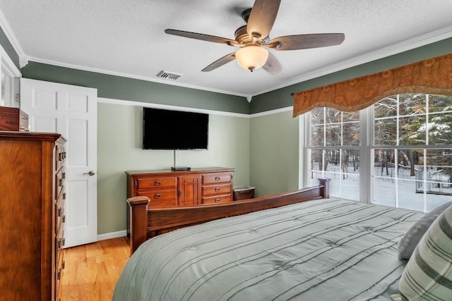 bedroom featuring ceiling fan, crown molding, a textured ceiling, and light wood-type flooring