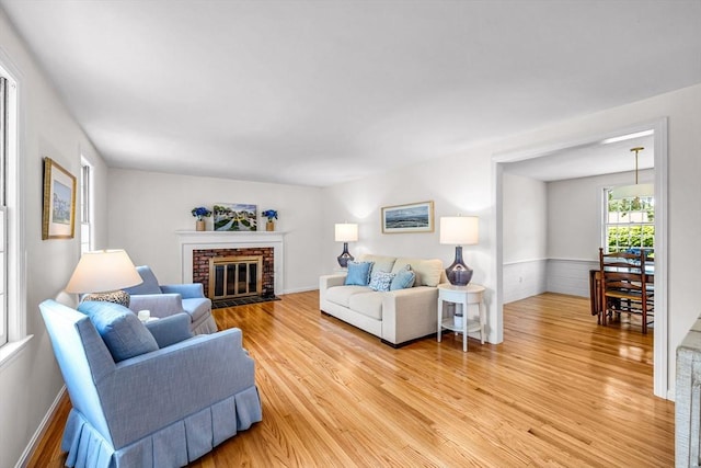 169 Mountainview Rd, East Longmeadow, MA 01028 - living room with light wood finished floors, a brick fireplace, and a wainscoted wall