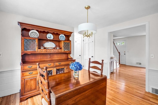169 Mountainview Rd, East Longmeadow, MA 01028 - dining space with light wood finished floors, a chandelier, stairway, and a wainscoted wall
