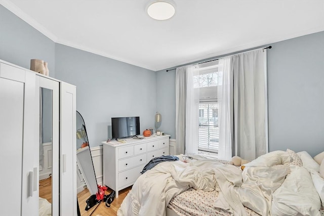 bedroom featuring crown molding and light hardwood / wood-style floors