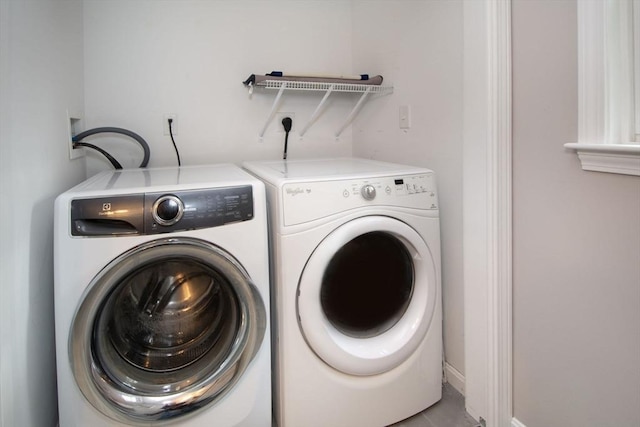 washroom featuring laundry area, washer and clothes dryer, and baseboards