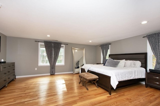 bedroom with baseboards, recessed lighting, and light wood-style floors