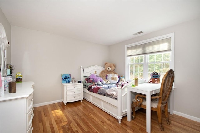 bedroom featuring light wood-type flooring, visible vents, and baseboards