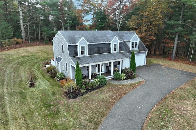 view of front of home featuring driveway, a garage, a porch, roof with shingles, and a front lawn