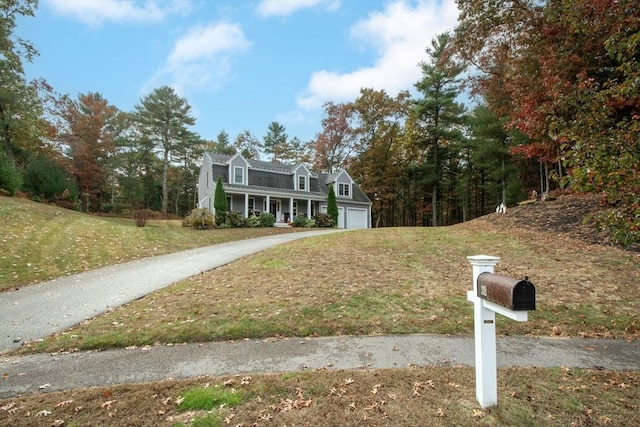 colonial inspired home featuring concrete driveway and a front lawn