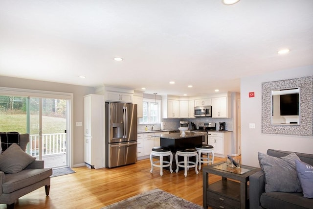 living room featuring recessed lighting, plenty of natural light, and light wood finished floors