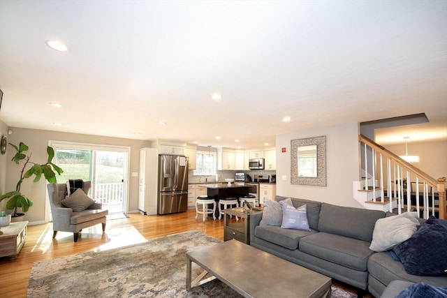 living room with stairway, light wood-style flooring, and recessed lighting