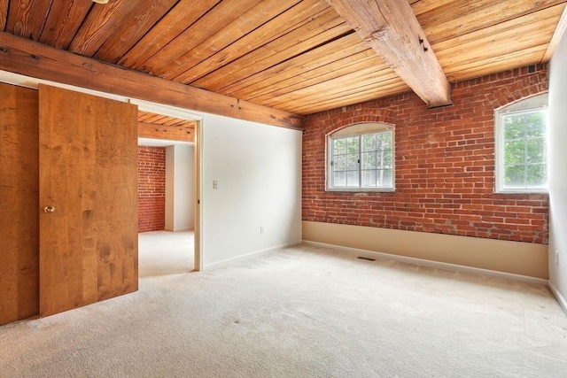 124 College St Unit 20, South Hadley, MA 01075 - carpeted spare room featuring wood ceiling with exposed beams, brick wall, and baseboards