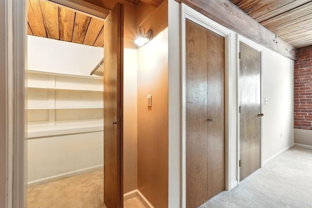 124 College St Unit 20, South Hadley, MA 01075 - hallway featuring carpet floors, wood ceiling, brick wall, and baseboards