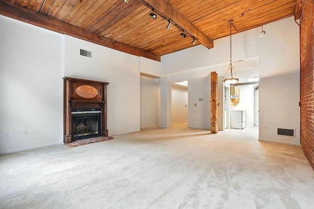 124 College St Unit 20, South Hadley, MA 01075 - unfurnished living room with a fireplace, washer / clothes dryer, wood ceiling with exposed beams, carpet flooring, and track lighting