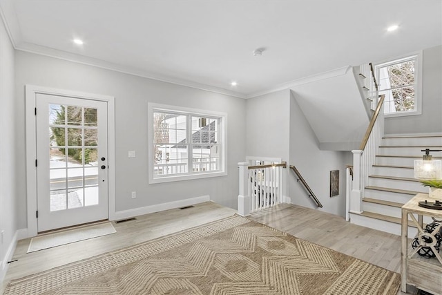 interior space with ornamental molding, a healthy amount of sunlight, and light wood-type flooring