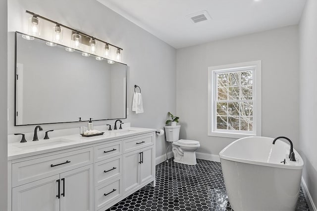 bathroom featuring vanity, toilet, and a tub to relax in