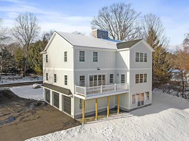 snow covered property with a garage