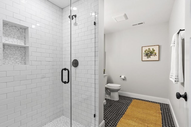 bathroom with a shower with shower door and toilet