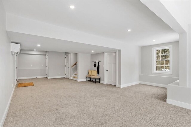 basement featuring light carpet and a wall mounted AC