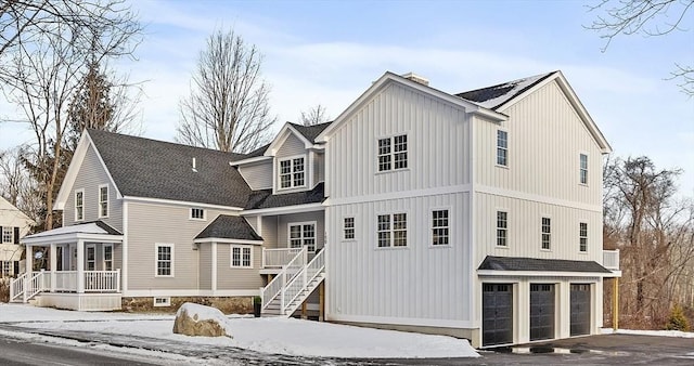 snow covered rear of property with a garage