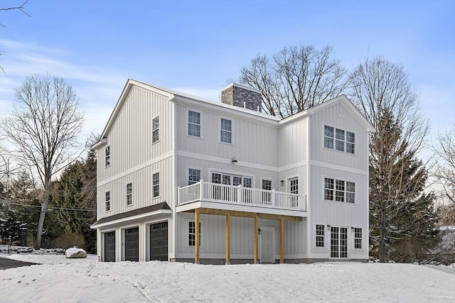 snow covered house featuring a garage