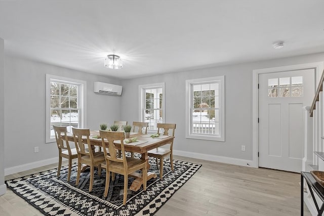 dining room featuring a wall mounted air conditioner and light wood-type flooring