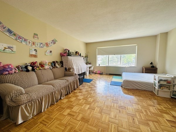 bedroom with light parquet flooring and a textured ceiling