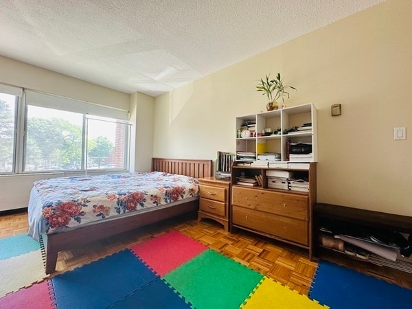 bedroom featuring parquet floors and a textured ceiling