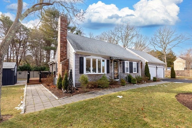 view of front facade with a garage, a front yard, and a deck