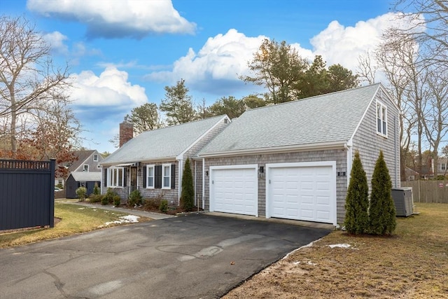 view of front facade with central AC, a garage, and a front lawn