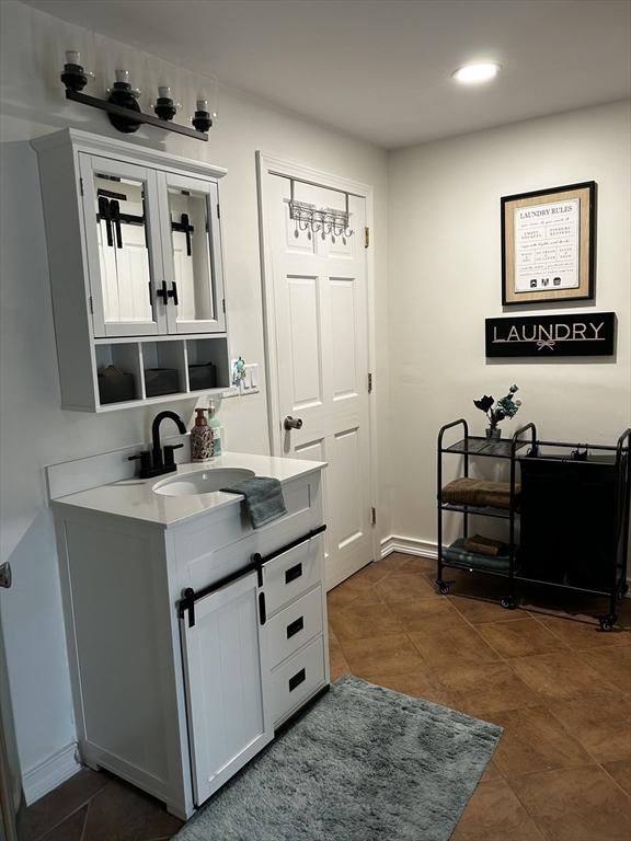 bathroom featuring recessed lighting, vanity, baseboards, and tile patterned floors