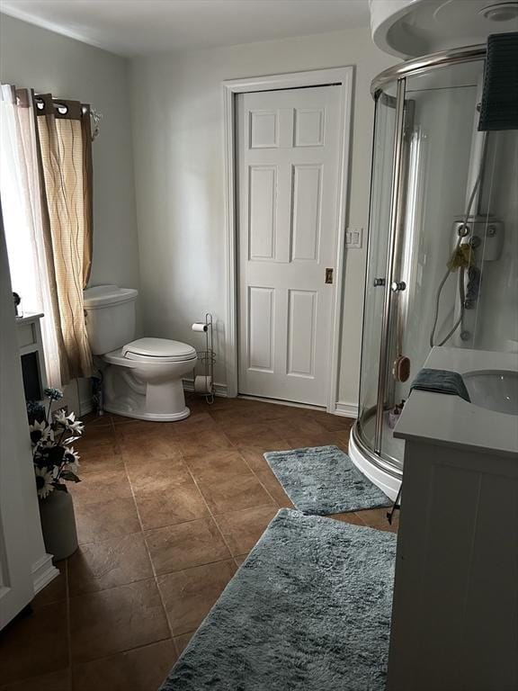 bathroom with vanity, a shower stall, and toilet