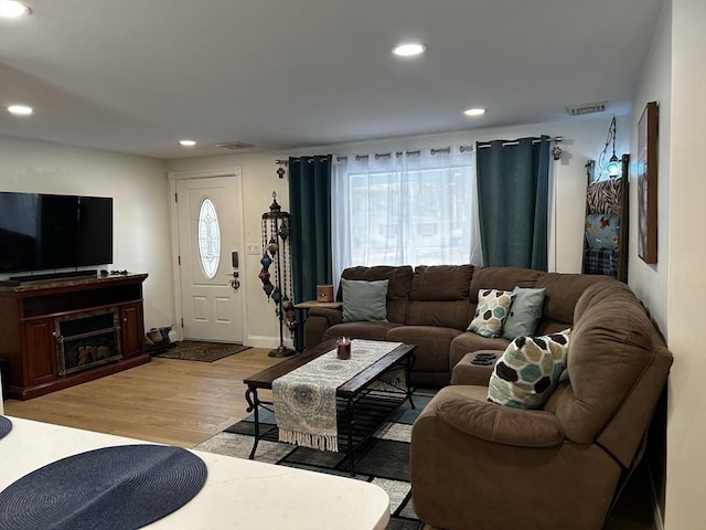 living room featuring light wood finished floors, visible vents, and recessed lighting