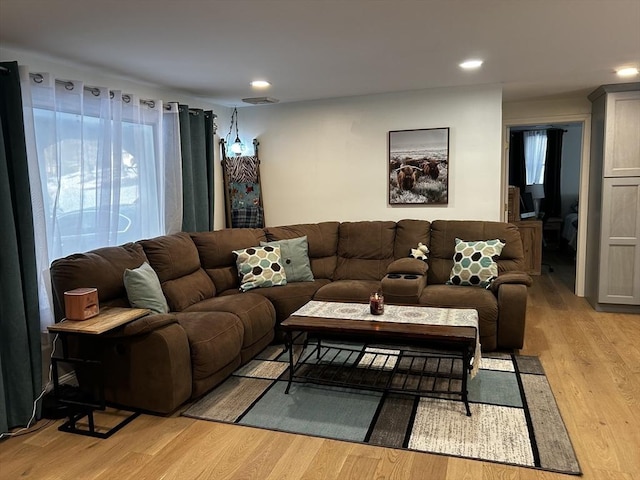 living room featuring light wood-style flooring, visible vents, and recessed lighting