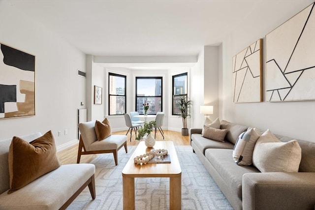 living room featuring visible vents, light wood-type flooring, and baseboards