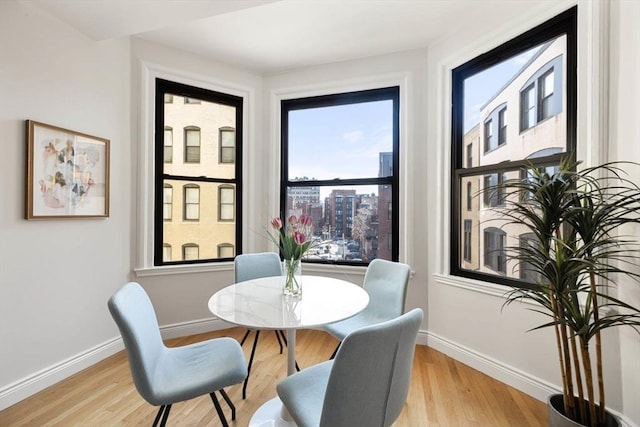 dining area featuring light wood-style floors and baseboards