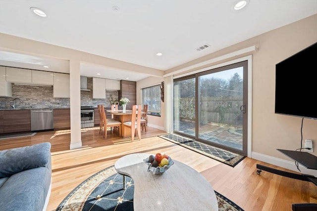 living room featuring sink and light wood-type flooring