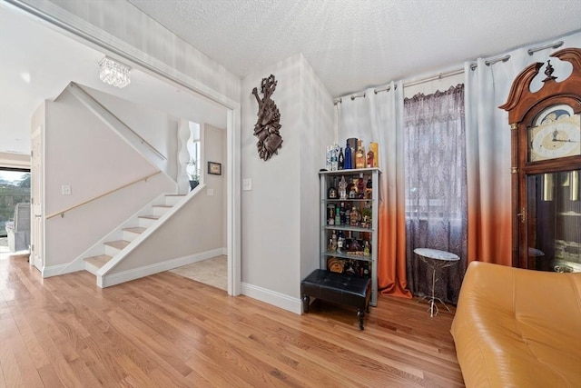 interior space with a textured ceiling and light hardwood / wood-style flooring