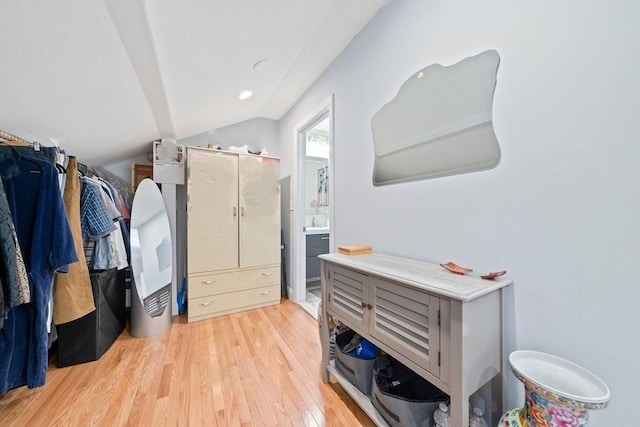 spacious closet with light hardwood / wood-style floors and lofted ceiling