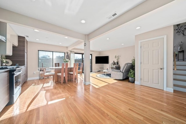 living room with beam ceiling and light wood-type flooring